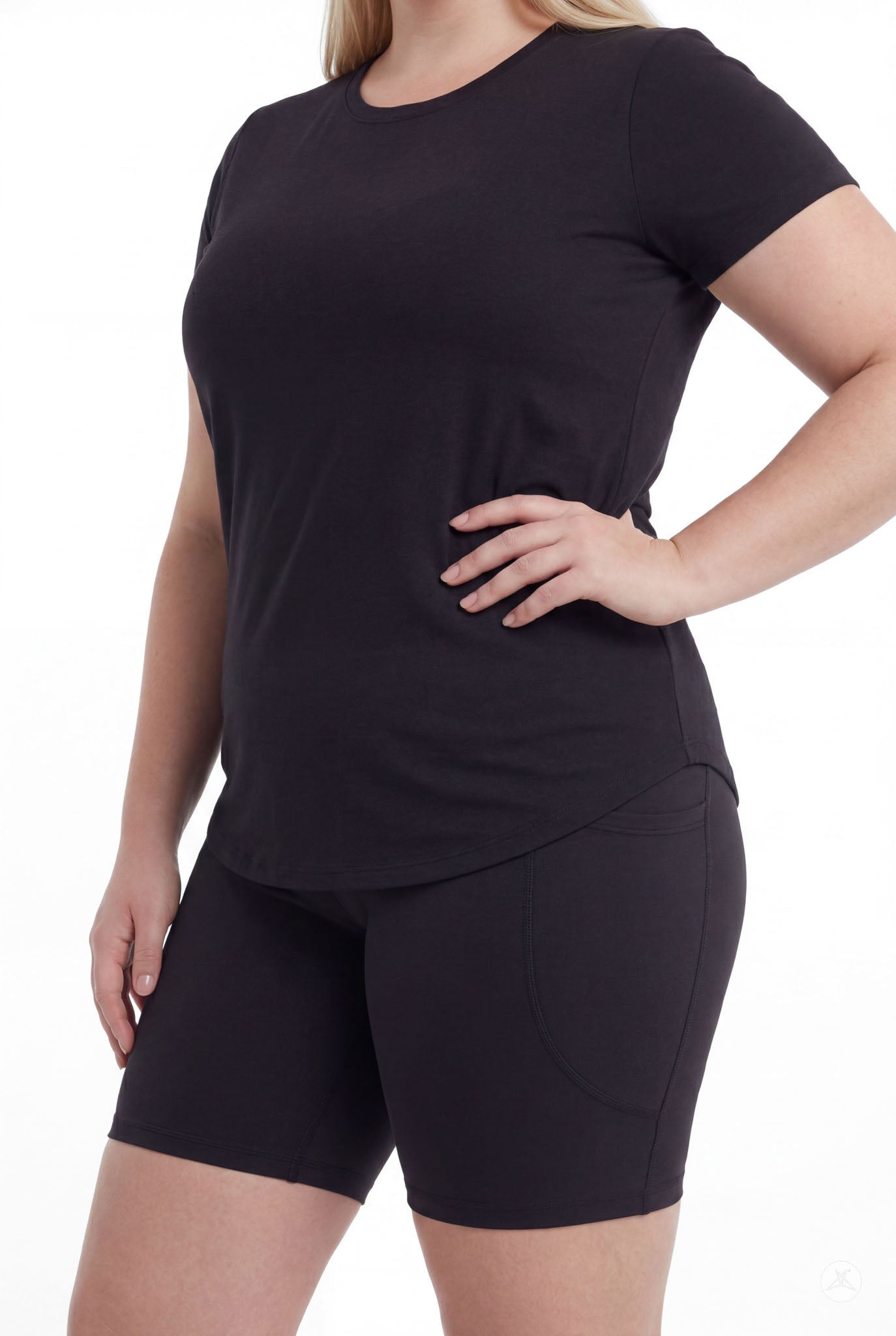 Plus size woman wearing SweetLegs Black Pocket Biker Shorts and black short sleeve top standing side view