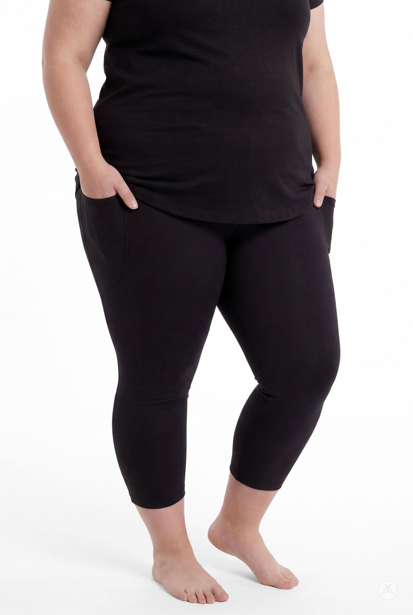 Plus size woman wearing SweetLegs Black Pocket Crops with hands in pockets and black top barefoot front view