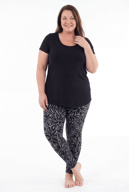 SweetLegs Shadow Petal Leggings modeled by a woman in a black and gray leafy print
