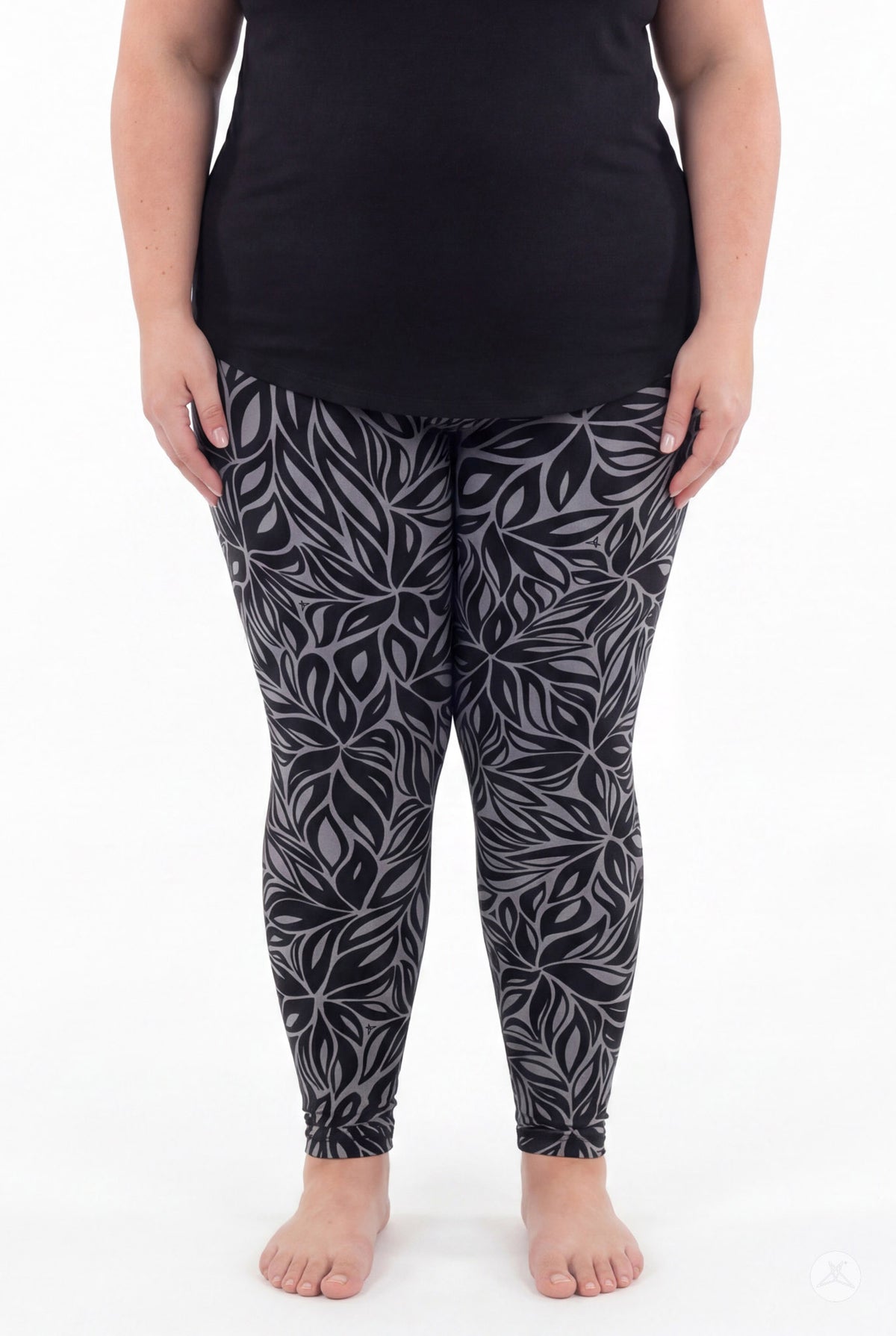 A model wears SweetLegs Shadow Petal Leggings in a dark gray botanical leaf print