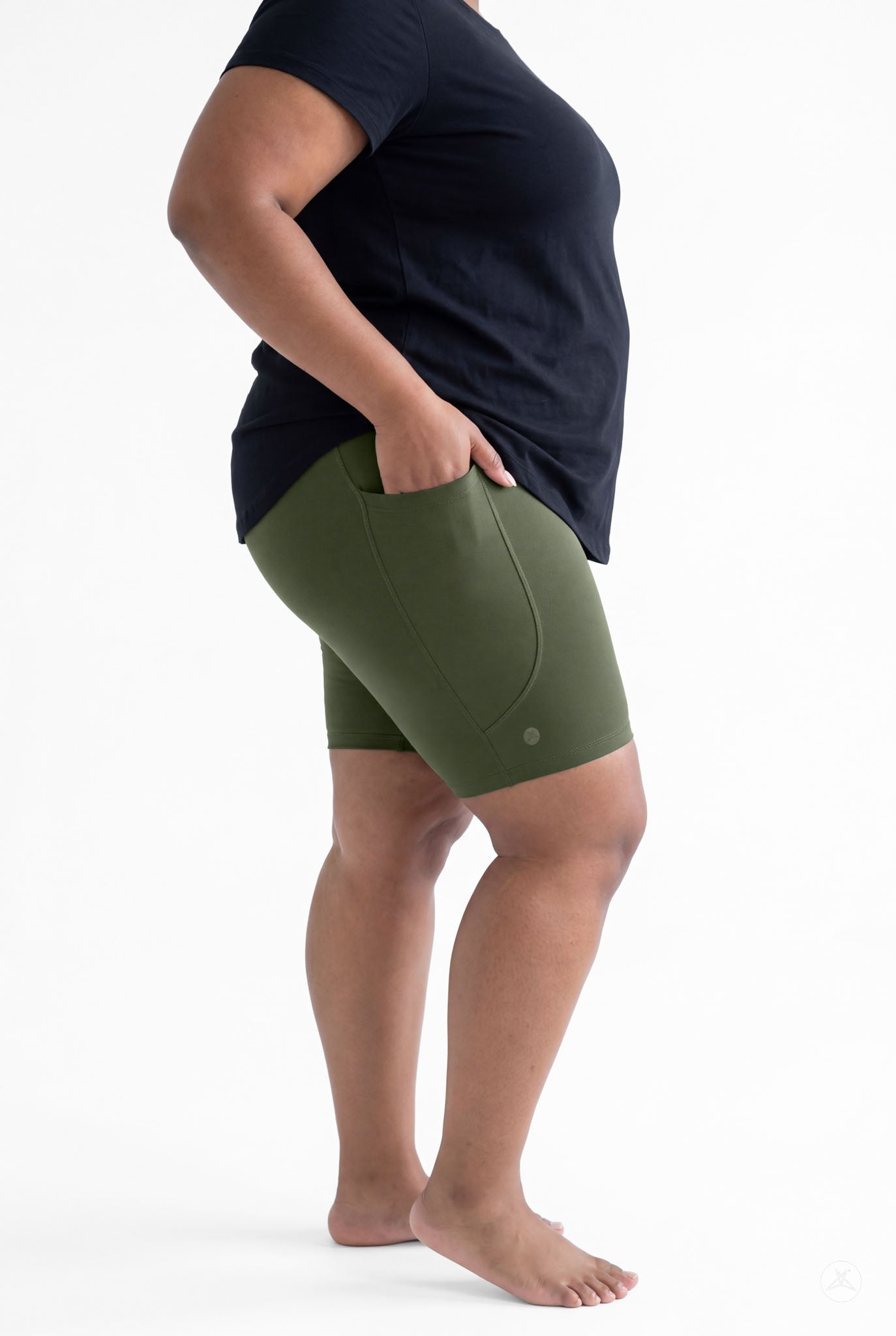 Plus size woman barefoot wearing SweetLegs Cedar Pocket Biker Shorts standing sideways with hand in side pocket