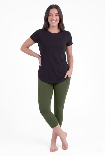 Smiling woman wearing SweetLegs Cedar Pocket Crops in olive green with side pockets and black short sleeve top