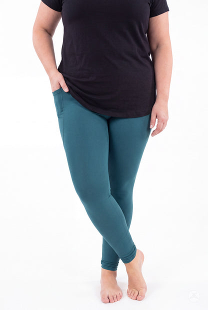 SweetLegs Deep Teal Pocket Leggings worn by a model in a black top with crossed ankles