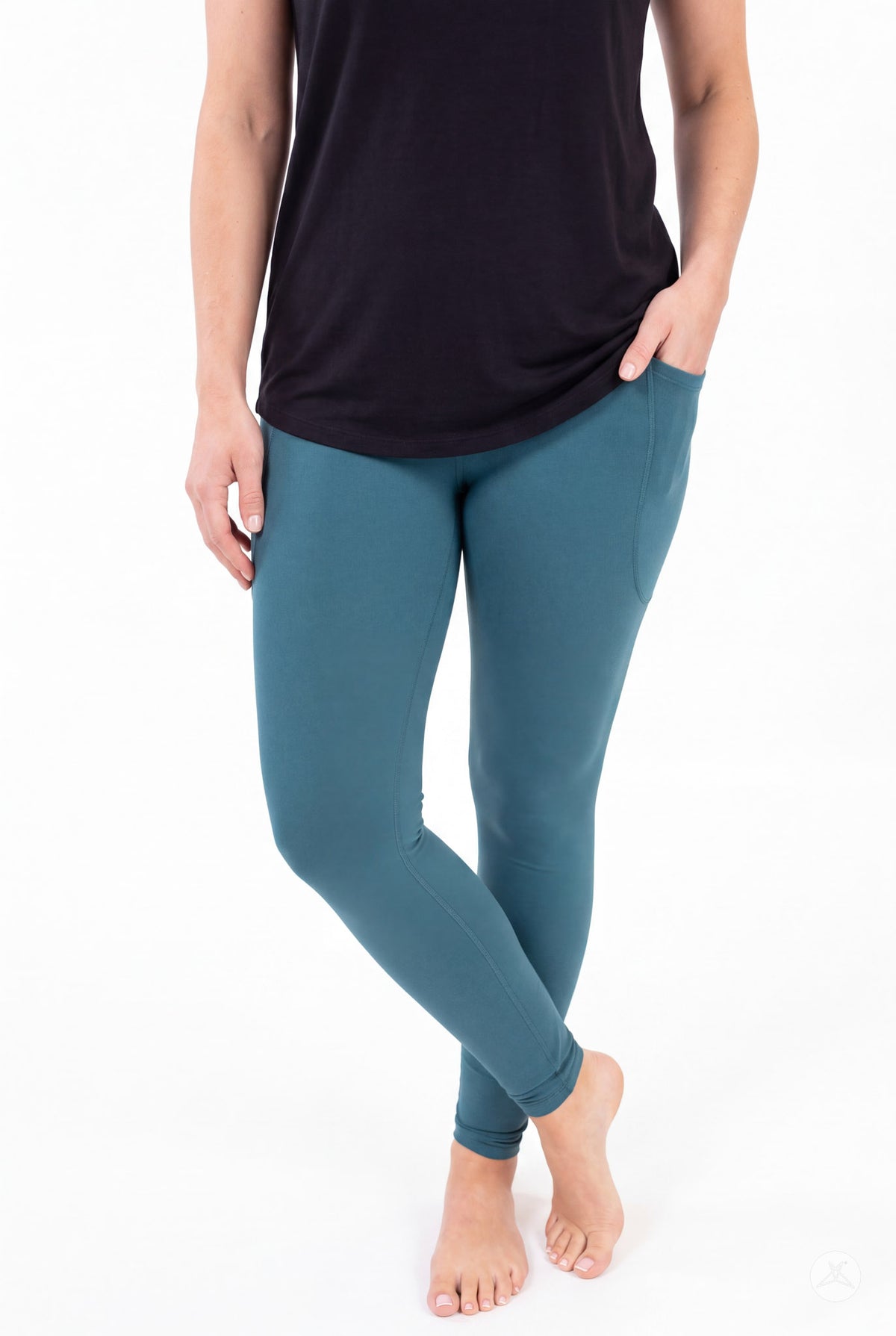 SweetLegs Deep Teal Pocket Leggings on a model with crossed ankles and hands in side pockets