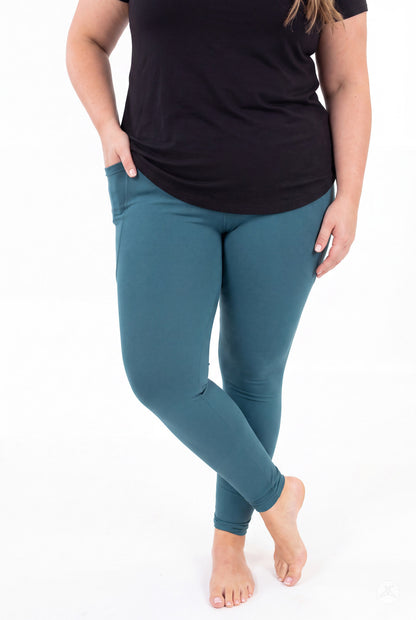 SweetLegs Deep Teal Pocket Leggings worn by a model in a black top with crossed ankles