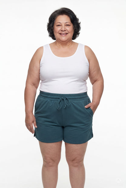 Smiling woman wearing teal Lounge Shorts by SweetLegs with elastic waistband, drawstring, and hands in pockets facing front