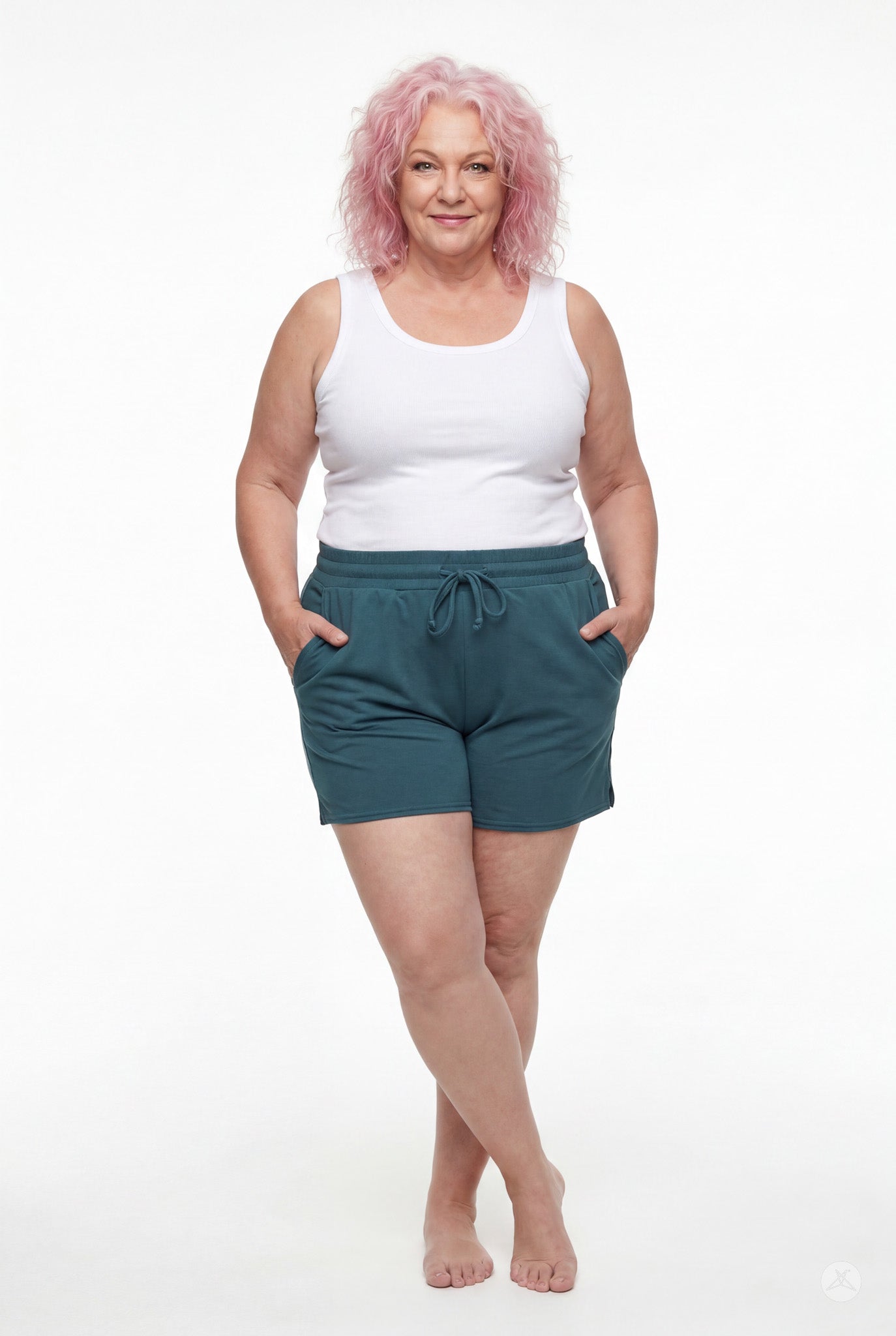 Woman with pink hair wearing teal Lounge Shorts by SweetLegs with drawstring waist and hands in pockets standing barefoot