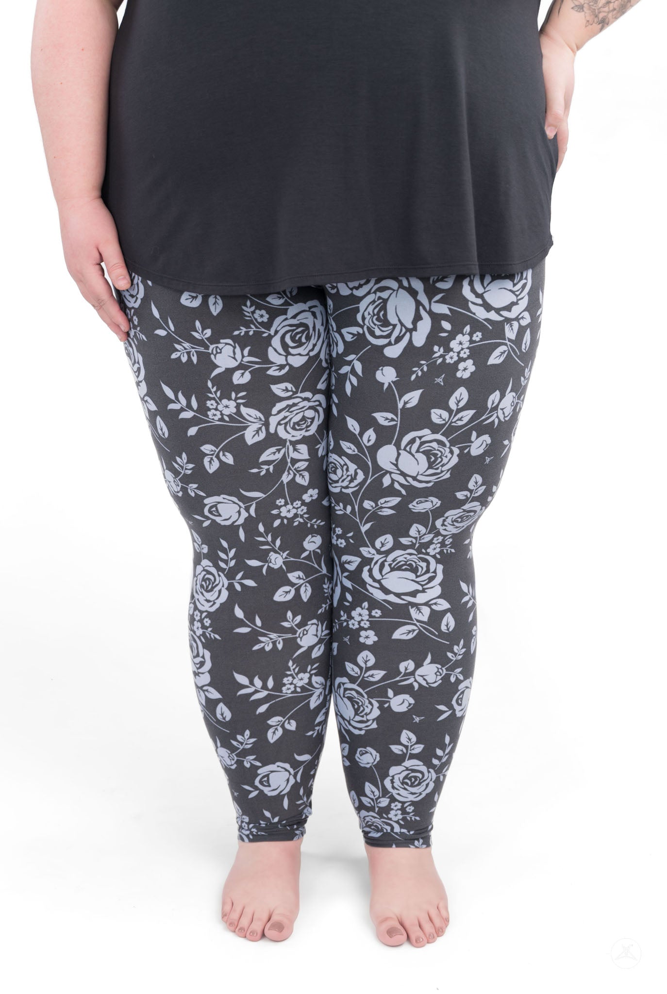 Shadow Garden leggings by SweetLegs featuring soft grey-blue roses on a deep dark background, worn by a plus-size model.