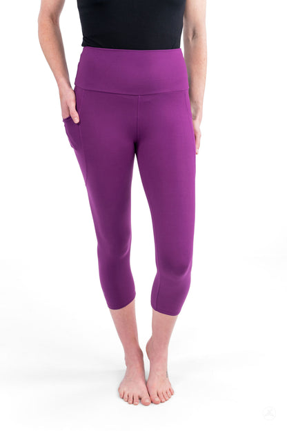 Woman wearing Deep Plum High-Waisted Pocket Crops by sweetlegs standing barefoot with hands in pockets against white background