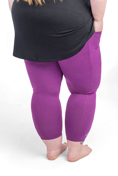 Plus size person barefoot facing away wearing sweetlegs Deep Plum Pocket Crops with black top and hands in pockets