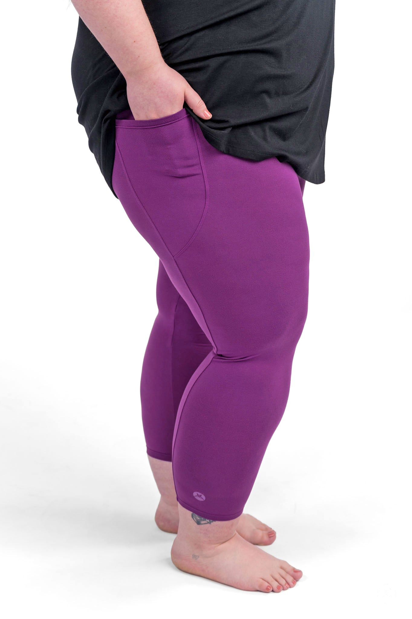 Plus size person barefoot wearing sweetlegs Deep Plum Pocket Crops with hand in pocket and black top visible from waist down
