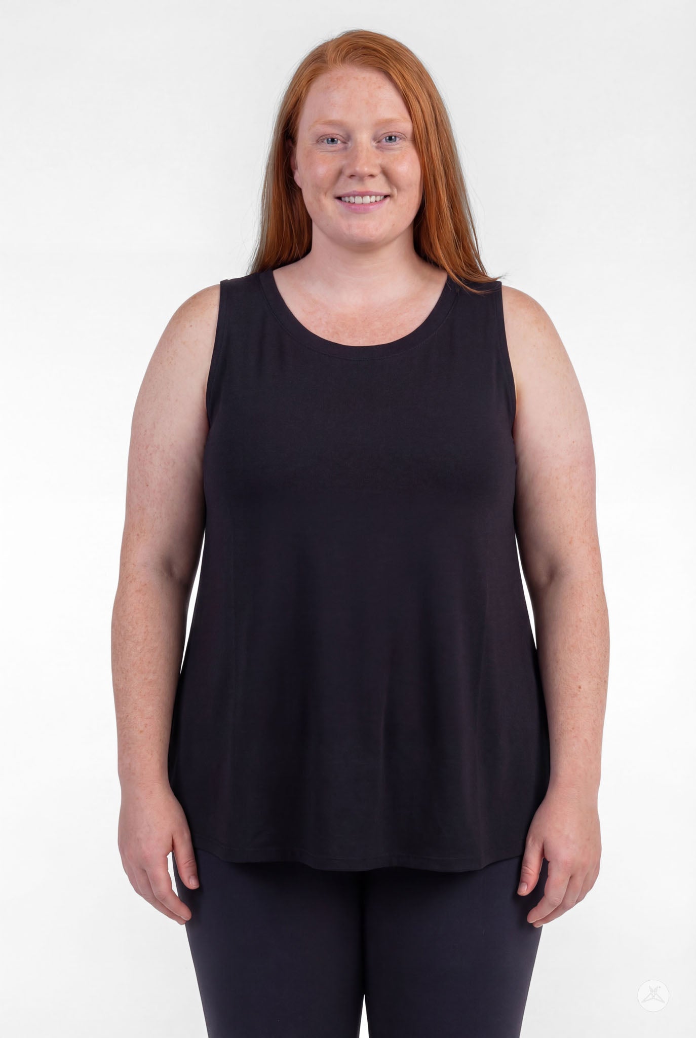 Plus size woman smiling wearing sleeveless black High Neck Tank by sweettops shown from front on white background