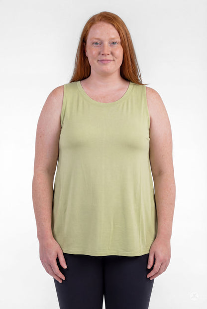 Plus size woman smiling wearing sleeveless light green High Neck Tank by sweettops standing relaxed facing forward