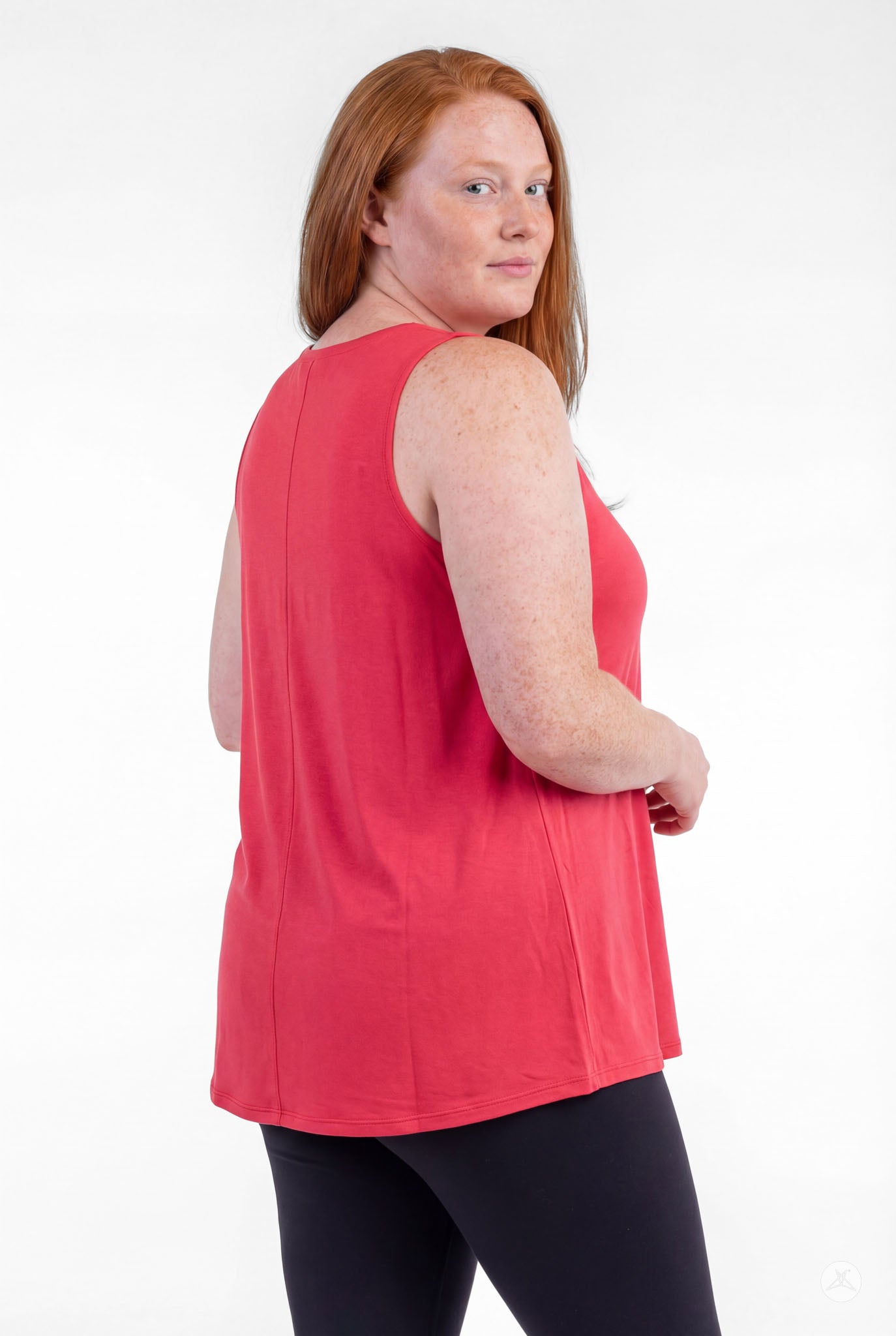 Plus size woman wearing coral red High Neck Tank by sweettops, turned slightly with relaxed confident expression