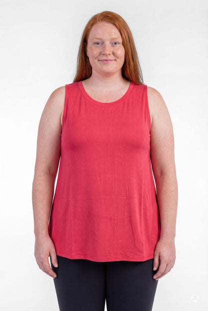 Plus size woman smiling wearing sweettops High Neck Tank in coral red with black pants, facing forward confidently
