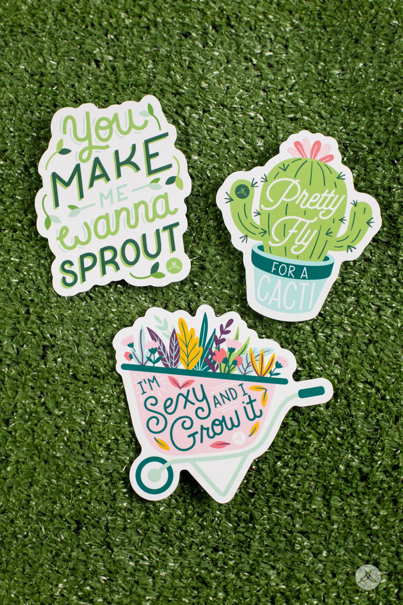 Three colorful stickers on grass featuring uplifting plant phrases from the Pretty Fly For A Cacti Sticker Pack by SweetLegs
