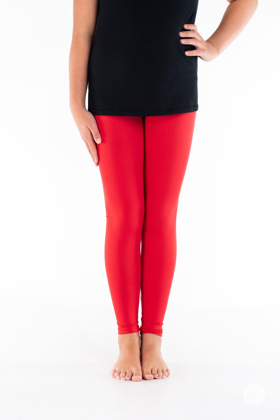 Child in SweetLegs Rosie Kids bright red solid leggings paired with black top standing barefoot on white background